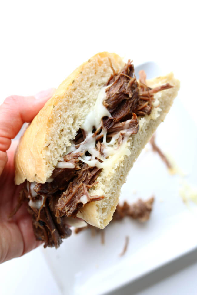 Slow Cooker Garlic Beef Sandwiches--fork tender roast beef that is flavored with garlic and other filipino adobo flavors. This recipe only has 6 ingredients. It's perfect to serve on rolls or over rice for an easy dinner that can feed a crowd. 