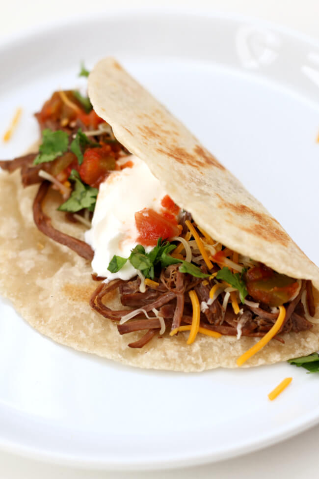 Slow Cooker Beef Barbacoa--flavorful, seasoned beef chuck roast that shreds like a dream and is perfect for so many different dinners. Try this barbacoa beef in cheesy quesadillas, crispy tacos, rolled up as enchiladas or piled on top of nachos. 