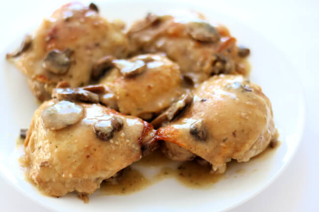 Slow Cooker Dijon Chicken--tender bites of bone-in chicken thighs and mushrooms are covered in a dijon, lemon and tarragon sauce.  