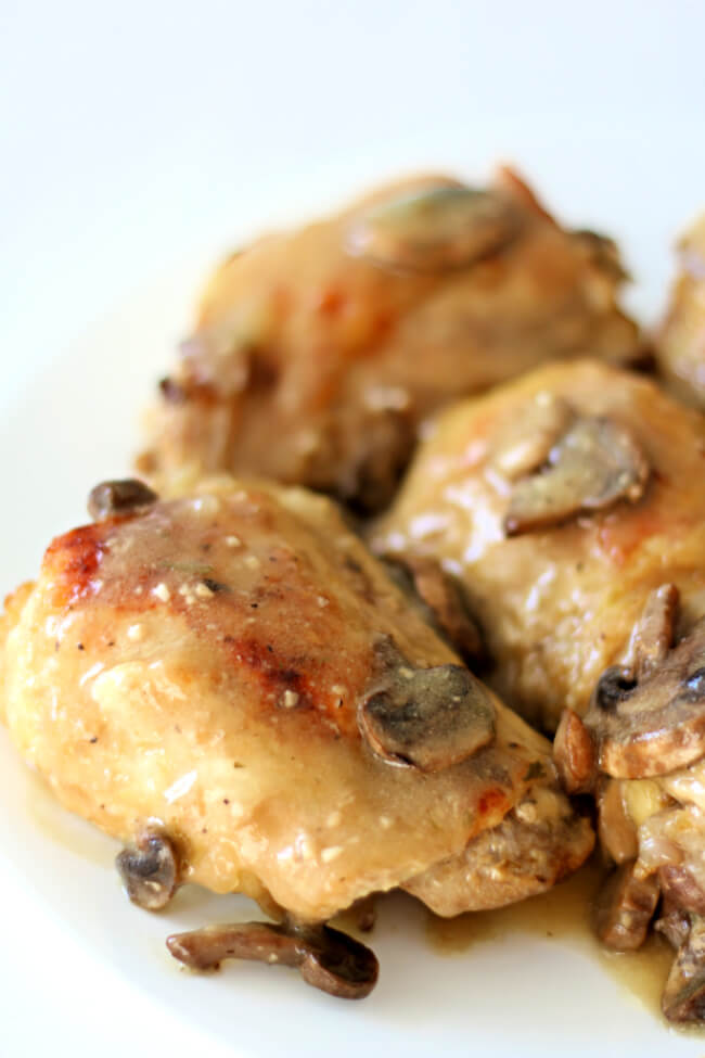 Slow Cooker Dijon Chicken--tender bites of bone-in chicken thighs and mushrooms are covered in a dijon, lemon and tarragon sauce.  