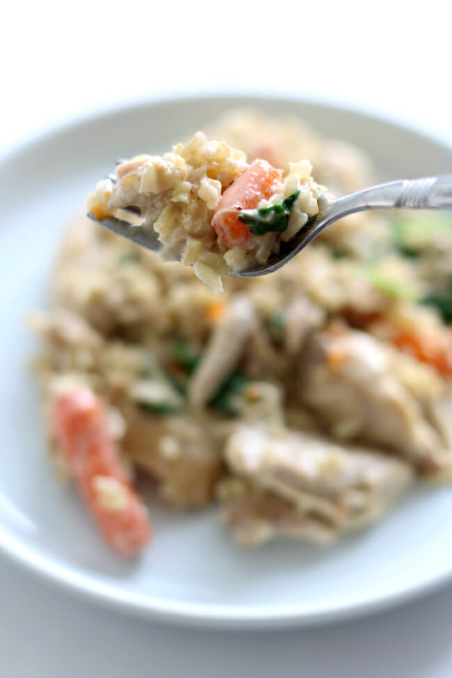 Slow Cooker Creamy Chicken Rice Dinner--a simple chicken and rice dinner with carrots and spinach. It's creamy but doesn't have any cream of soups in it and takes just a few minutes to dump everything in and go. 
