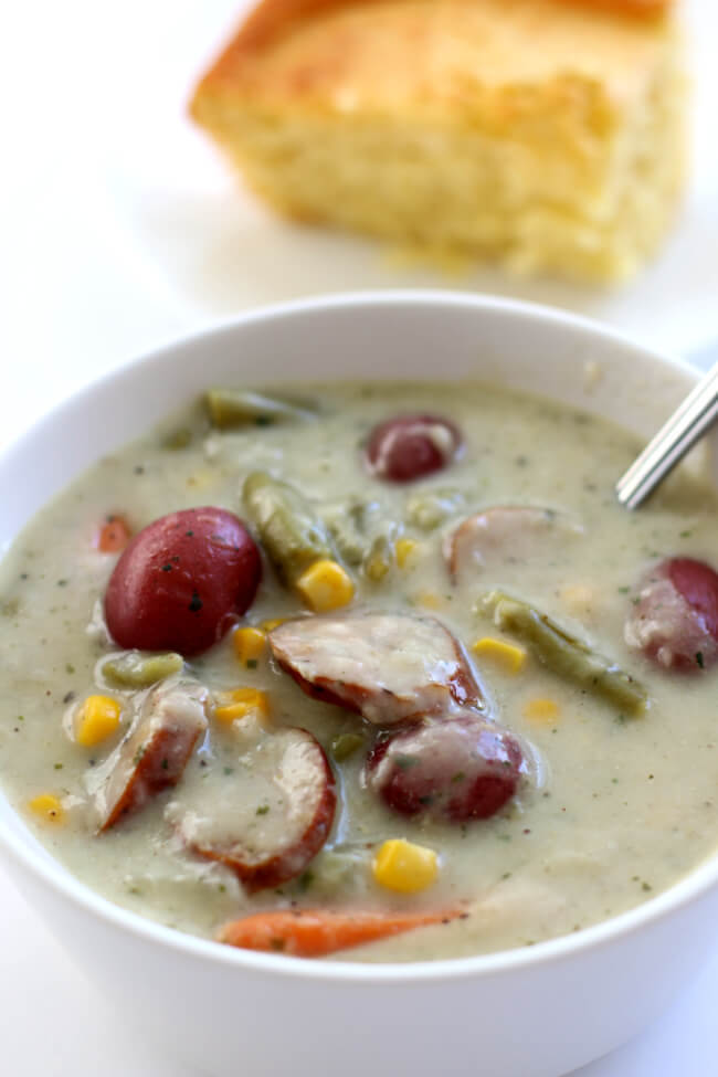 Slow Cooker Garlic Parmesan Sausage Chowder--a colorful and flavorful summer chowder with garlic, smoked sausage, parmesan cheese, corn, potatoes, green beans and carrots. Your whole family will love this soup!