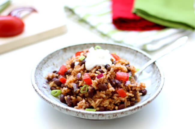 Instant Pot Mexican Black Beans and Rice--the easiest and tastiest rice ever! Brown rice is cooked in flavorful salsa with garlic salt, a bay leaf and cumin. Canned black beans make this recipe very convenient. And my favorite part is a squeeze of lime juice and a dollop of sour cream on top. Make this as a meal or as a side dish.