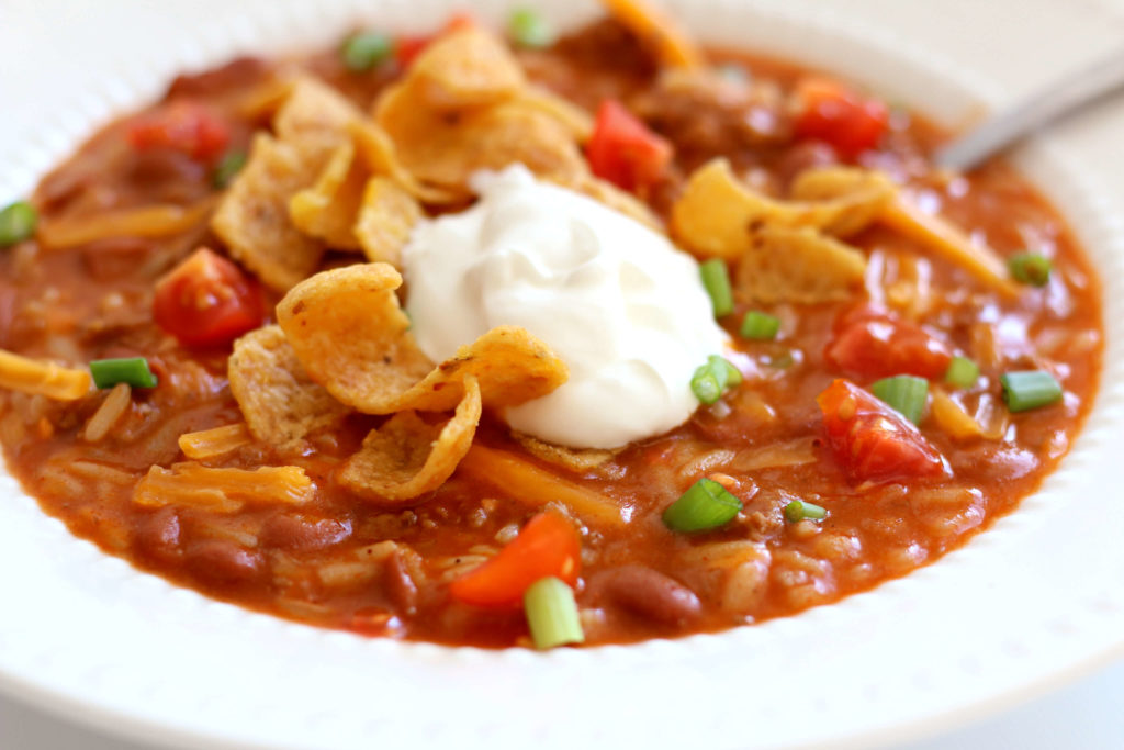bowl of chili with sour cream and fritos 