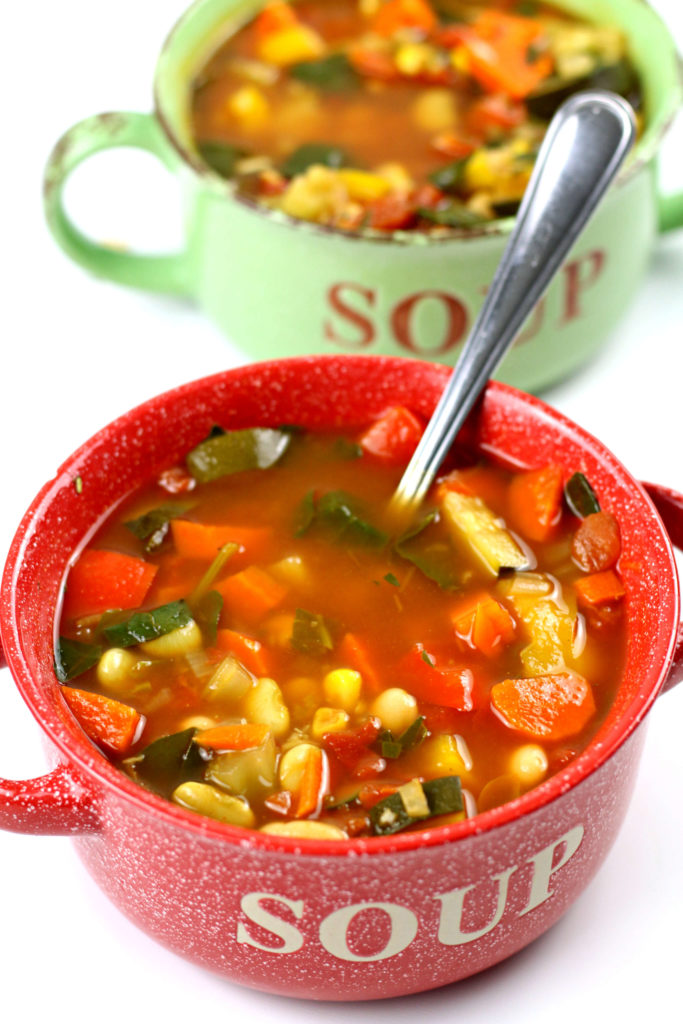 two bowls of colorful vegetable soup
