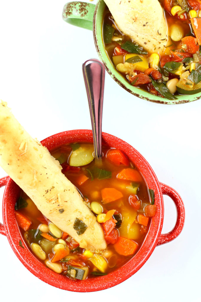 vegetable soup with breadsticks in it