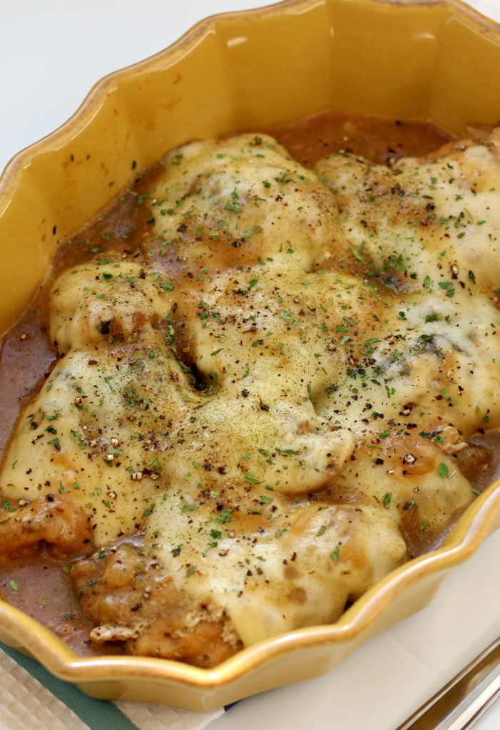 chicken with white cheese in a yellow baking dish