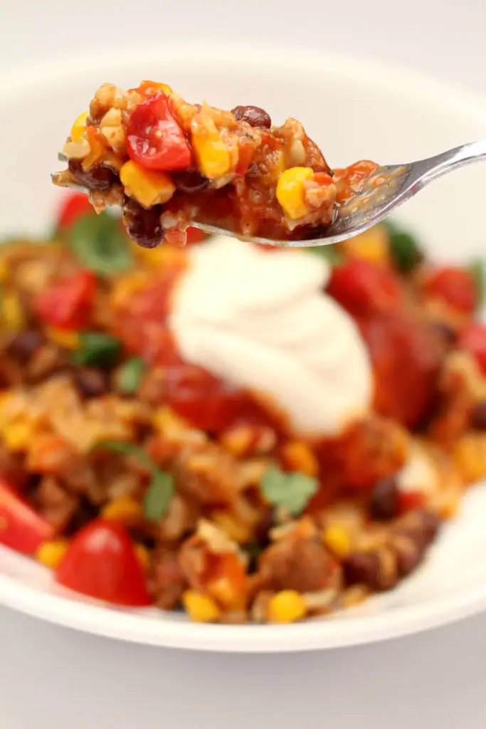 beef burrito bowls in a white bowl with sour cream on top
