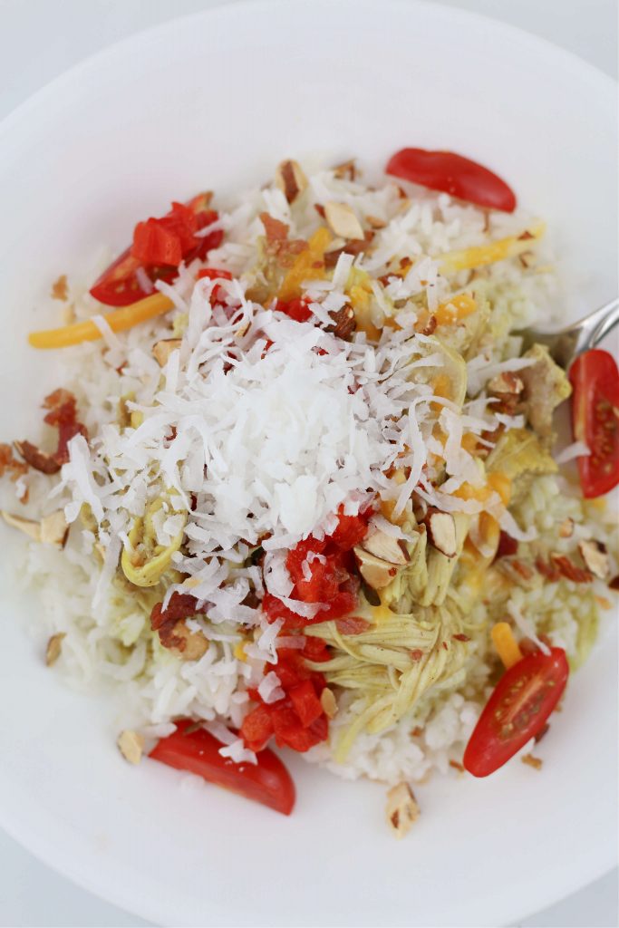 rice with chicken, almonds, cheese, tomatoes and coconut on top