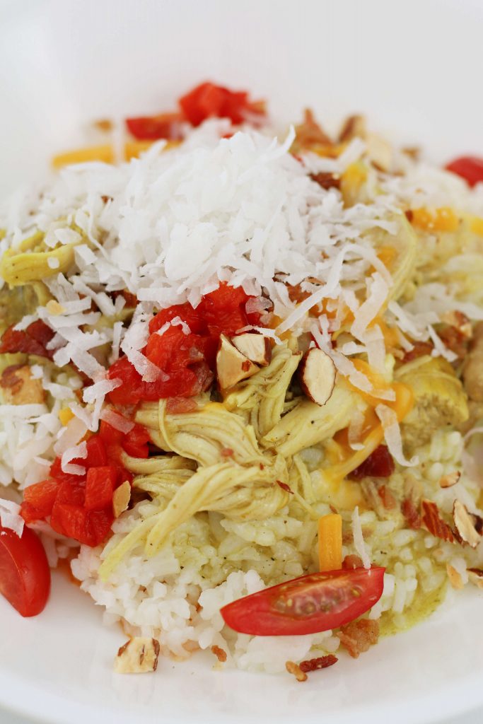 rice with chicken, almonds, cheese, tomatoes and coconut on top