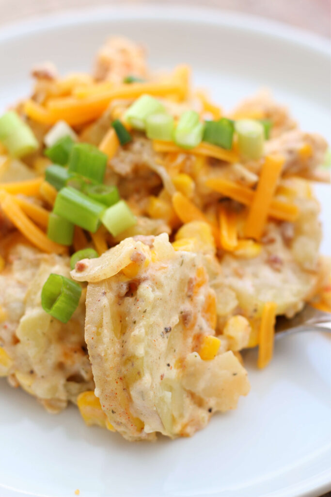 Instant Pot Loaded Chicken and Potato Casserole--potatoes, chicken and corn coated with French onion dip, seasonings, bacon crumbles and cheese. An easy to make but delicious to eat dinner!