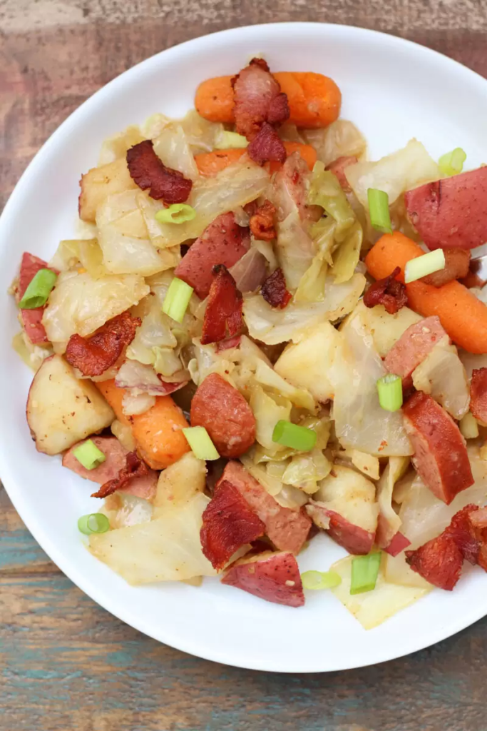 Instant Pot Cabbage, Potatoes and Sausage is such an easy and delicious one pot supper. With bacon and sausage it’s got lots of flavor. Plus you get your vegetables in with the cabbage, carrots and red potatoes.