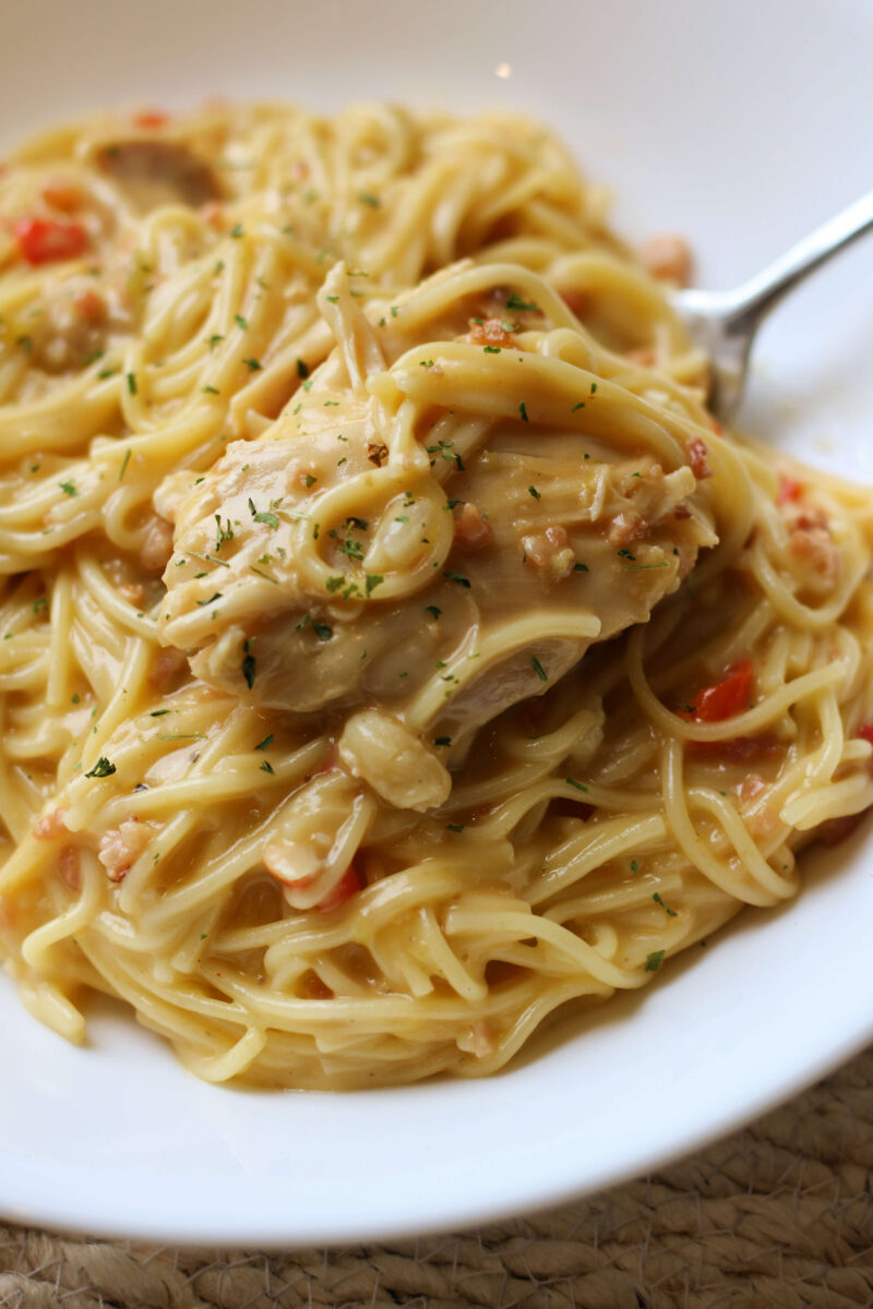 Instant Pot creamy chicken bacon pasta with angel hair noodles, shredded chicken, pimentos, and cheddar cheese sauce