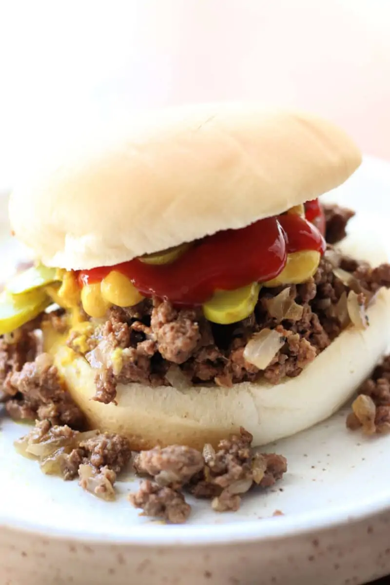 Crock Pot Iowa Maid Rites--an easy slow cooker loose meat sandwich made with seasoned ground beef and onions. It's piled onto buns and topped with crunchy dill pickles.