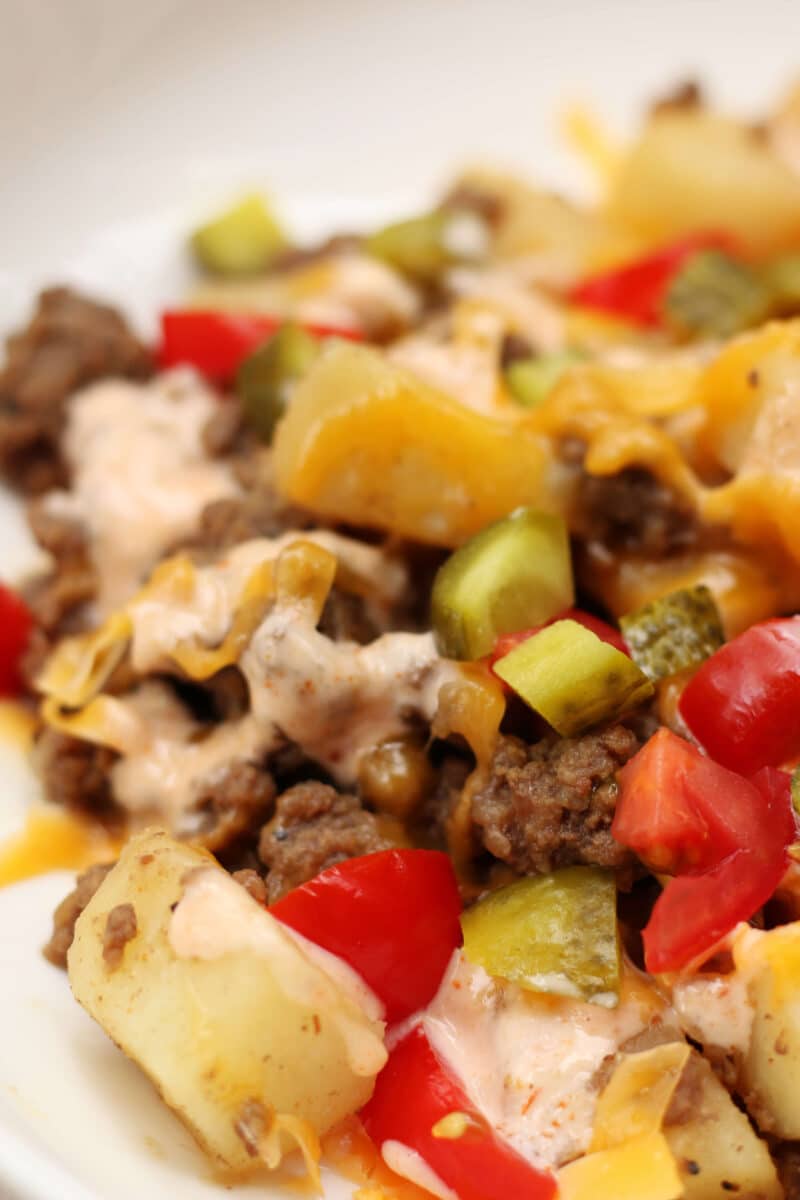 In-N-Out Animal Style Cheeseburger Casserole--an easy Instant Pot dinner with seasoned ground beef, tender potatoes, melted cheddar cheese, pickles, tomatoes and a creamy homemade burger sauce.