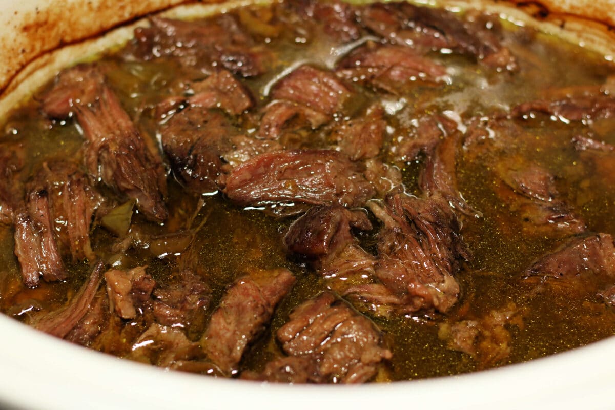 Tender Slow Cooker Mississippi Pot Roast--tender chuck roast, au jus seasoning, pepperoncini peppers and butter for a juicy, flavorful beef dinner with just five ingredients that you can make in the slow cooker or the Instant Pot.