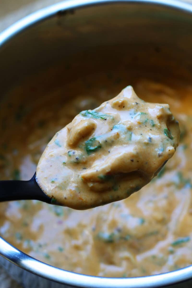 Tuscan Style Crockpot Chicken--an easy slow cooker or Instant Pot dinner made with tender chicken thighs, whole garlic cloves, Parmesan, spinach and a sun-dried tomato pesto cream sauce.