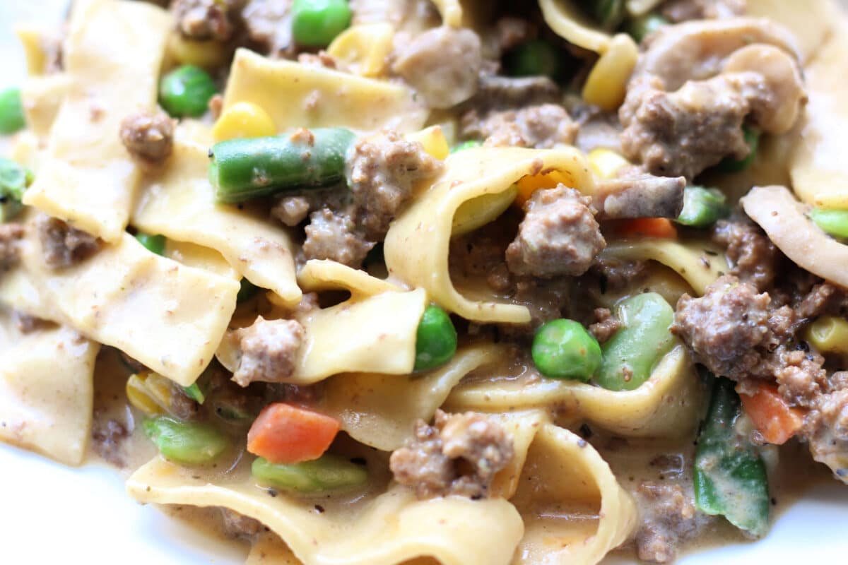 Dolly Parton's Creamy Beef Noodle Casserole--an easy one-pot dinner made with seasoned ground beef, tender egg noodles, vegetables, mushrooms, sour cream and cheddar cheese.