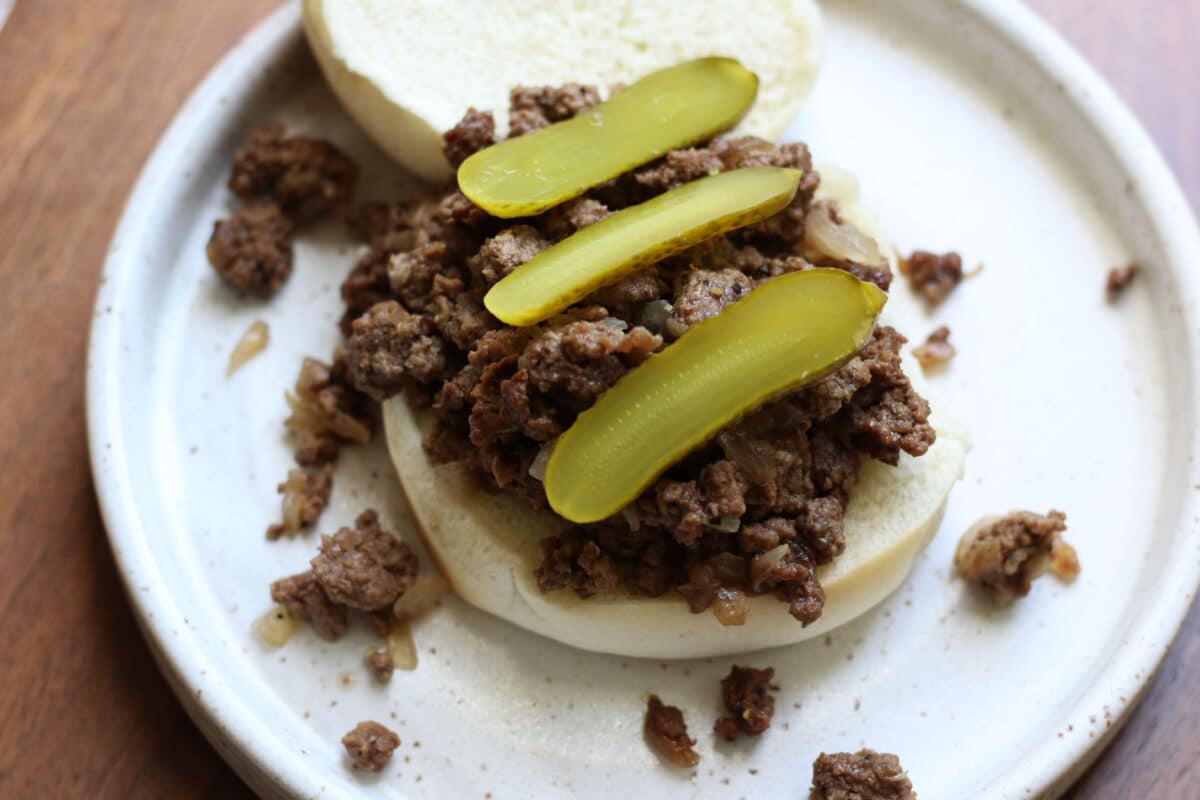 Crock Pot Iowa Maid Rites--an easy slow cooker loose meat sandwich made with seasoned ground beef and onions. It's piled onto buns and topped with crunchy dill pickles.
