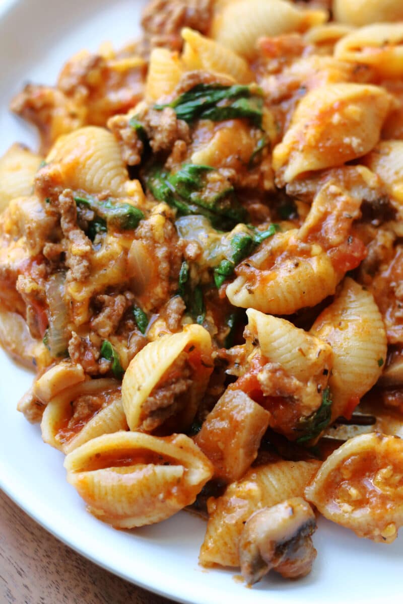 Amish Frolic Casserole--an easy Instant Pot pasta dinner made with ground beef, medium pasta shells, tomato basil sauce, fresh spinach, mushrooms and melty cheddar cheese.