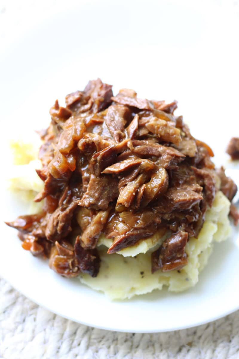 Slow Cooker Round Steak and Gravy--tender beef, onions, garlic and au jus gravy for a simple dump-and-go dinner that’s perfect served over mashed potatoes or egg noodles.