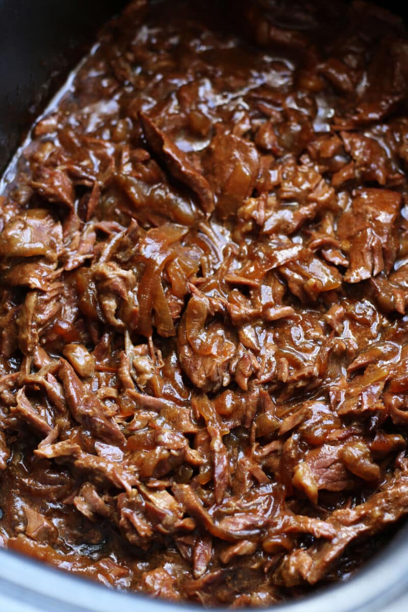Slow Cooker Round Steak and Gravy--tender beef, onions, garlic and au jus gravy for a simple dump-and-go dinner that’s perfect served over mashed potatoes or egg noodles.