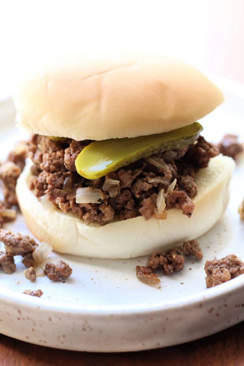 Crock Pot Iowa Maid Rites--an easy slow cooker loose meat sandwich made with seasoned ground beef and onions. It's piled onto buns and topped with crunchy dill pickles.