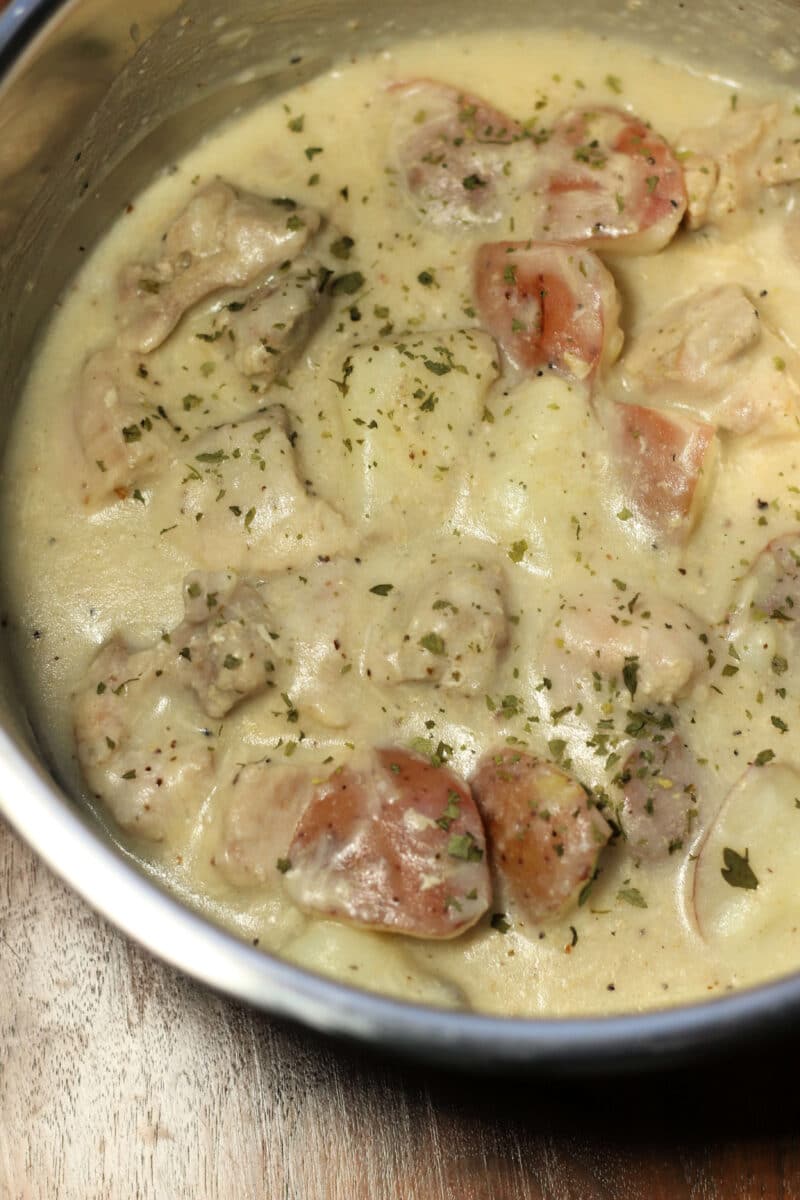Creamy Garlic Parmesan Chicken and Potatoes--an easy Instant Pot or slow cooker dinner made with tender chicken thighs, red potatoes, plenty of garlic and a creamy lemon Parmesan sauce.