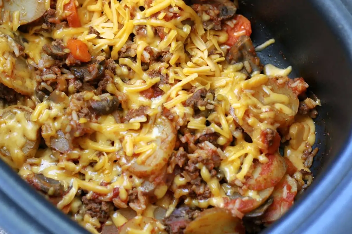 Crock Pot Kitchen Sink Casserole--a slow cooker dinner made with seasoned ground beef, tender potatoes, carrots, mushrooms, rice, tomato sauce and melted cheddar cheese...everything but the kitchen sink ;)