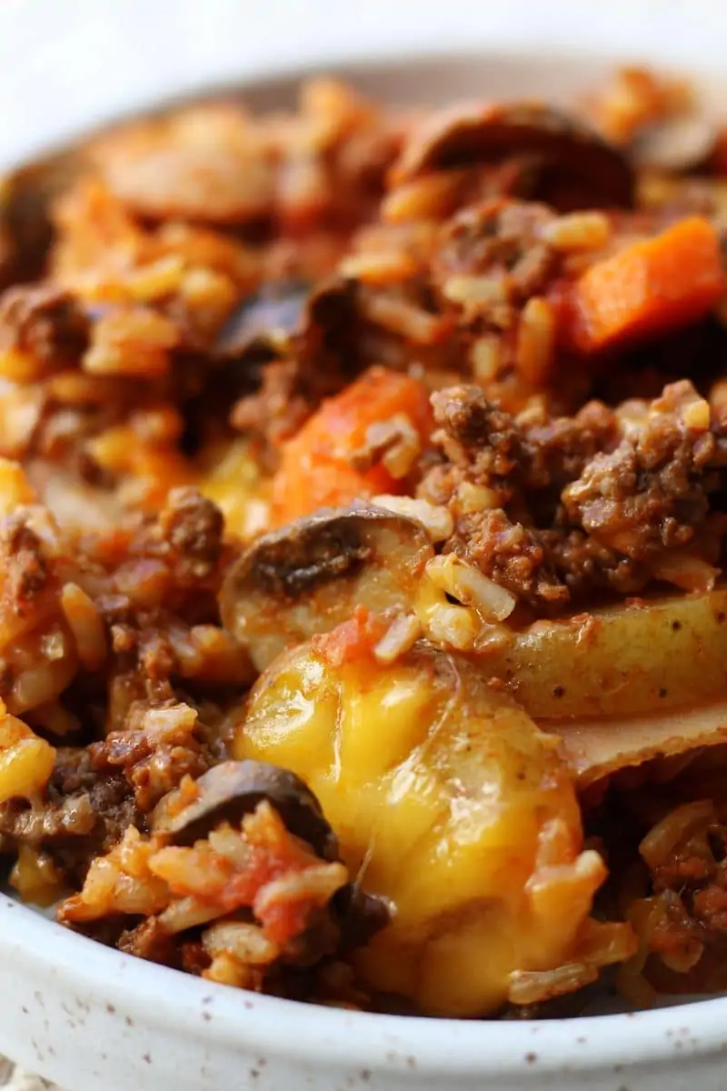 Crock Pot Kitchen Sink Casserole--a slow cooker dinner made with seasoned ground beef, tender potatoes, carrots, mushrooms, rice, tomato sauce and melted cheddar cheese...everything but the kitchen sink ;)