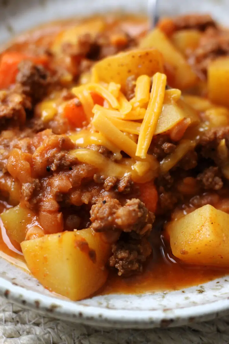 Slow Cooker Lumberjack Casserole--a crockpot meal made with ground beef, tender potatoes, carrots, mushrooms, pork and beans and melted cheddar cheese.