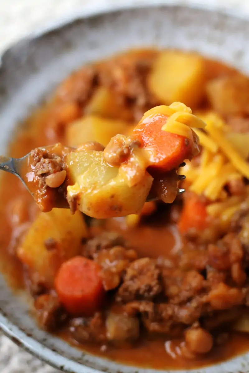 Slow Cooker Lumberjack Casserole--a crockpot meal made with ground beef, tender potatoes, carrots, mushrooms, pork and beans and melted cheddar cheese.