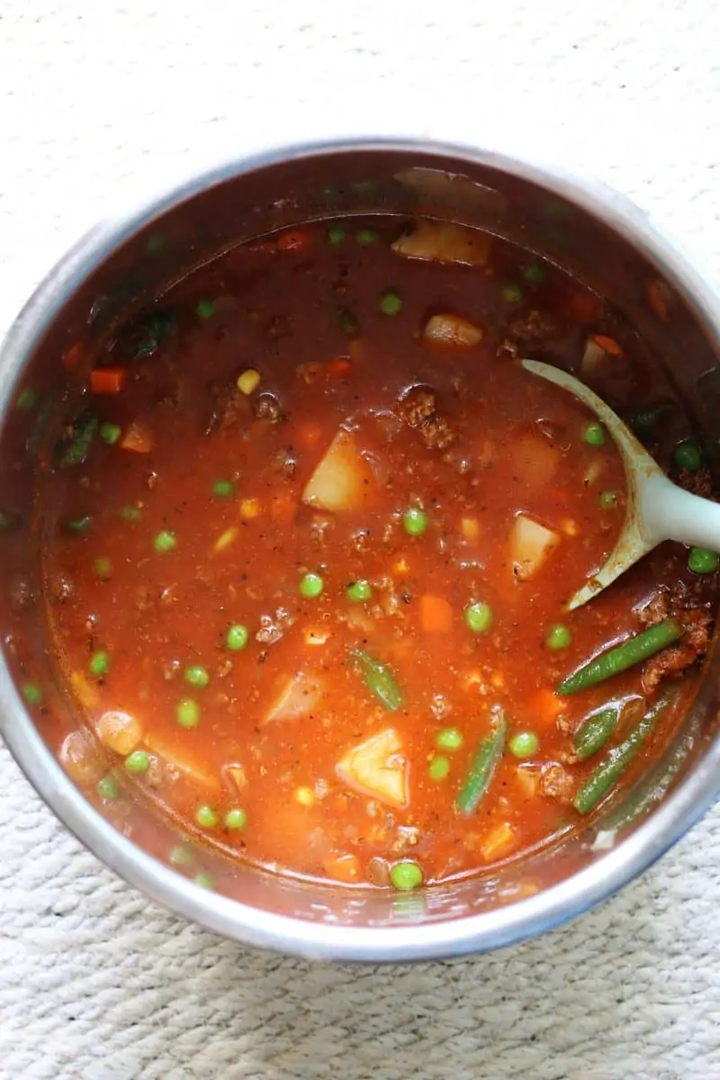 Crock Pot Vegetable Beef Soup--this cozy soup has tender potatoes, mixed vegetables, tomatoes and savory ground beef and can be made in the Instant Pot or slow cooker.