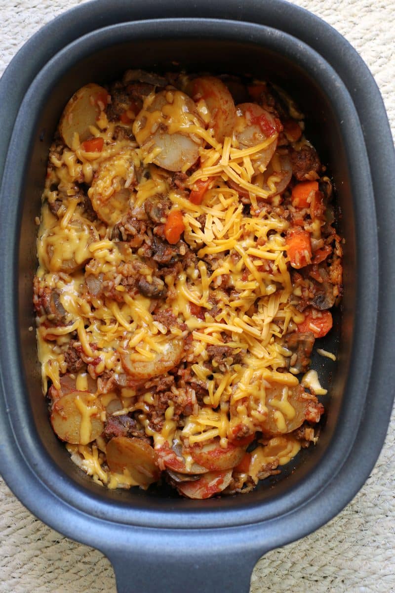 Crock Pot Kitchen Sink Casserole--a slow cooker dinner made with seasoned ground beef, tender potatoes, carrots, mushrooms, rice, tomato sauce and melted cheddar cheese...everything but the kitchen sink ;)