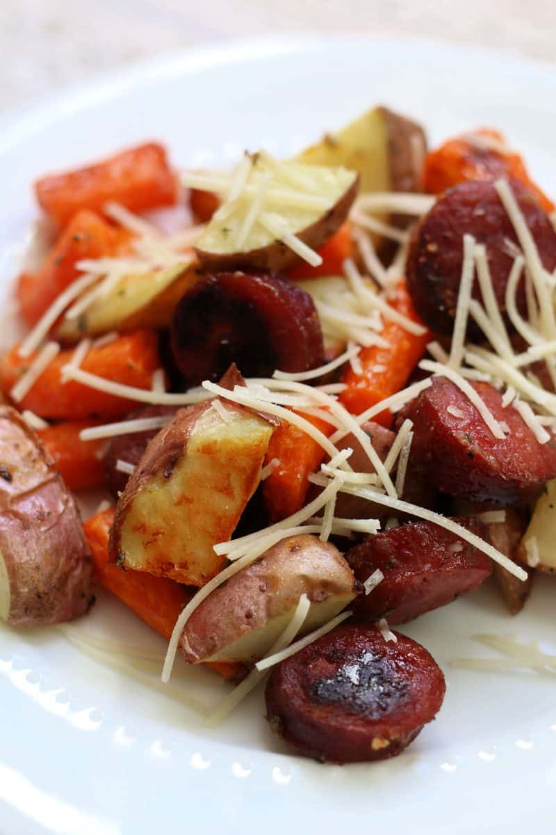 Ranch Potatoes & Smoked Sausage--an easy sheet pan dinner with smoky sausage, tender potatoes and carrots tossed with ranch seasoning, then topped with Parmesan cheese.