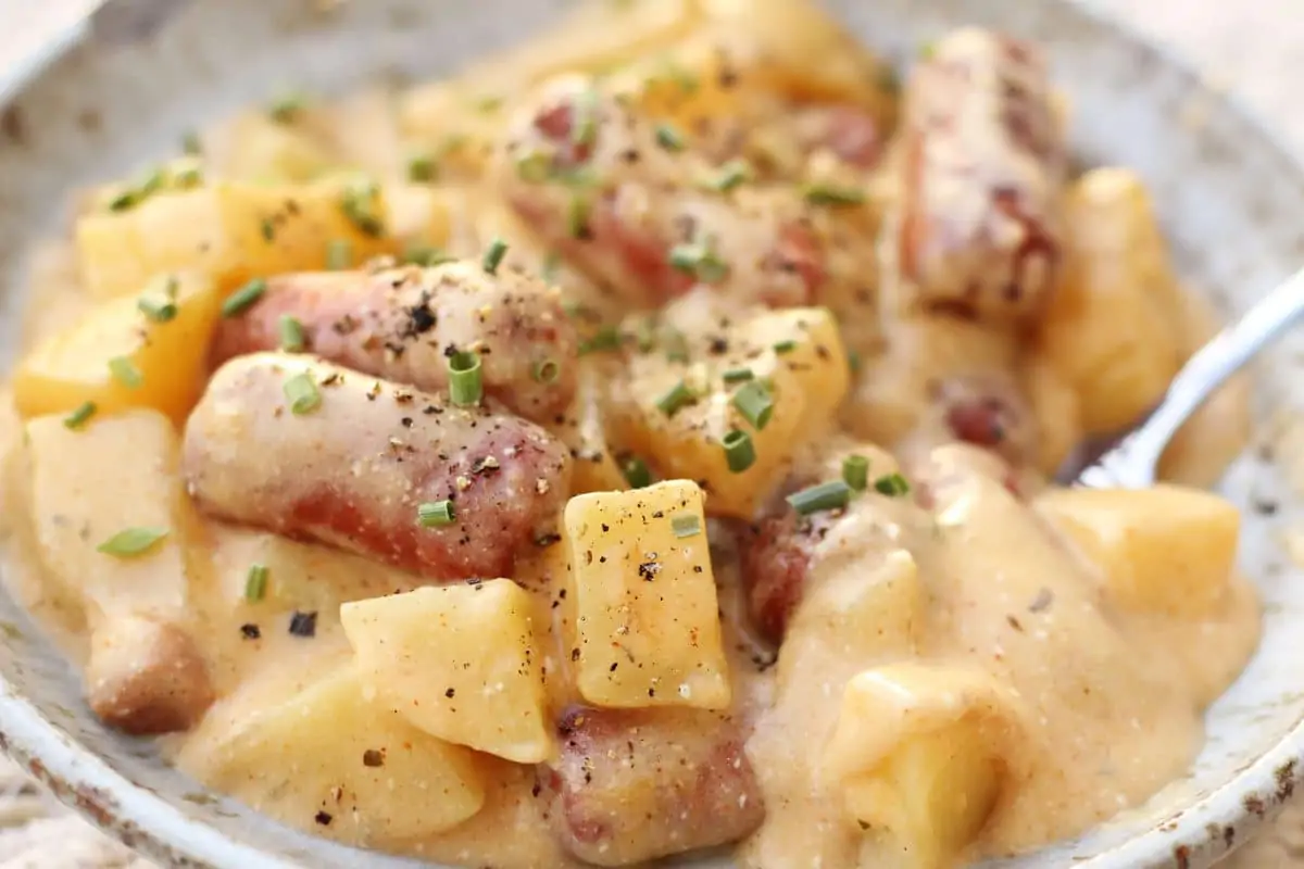 Crock Pot Little Smokies and Cheesy Potato Casserole--an easy crockpot dinner made with tender Yukon gold potatoes, smoky sausages, Cajun seasoning and a creamy, cheesy sauce.