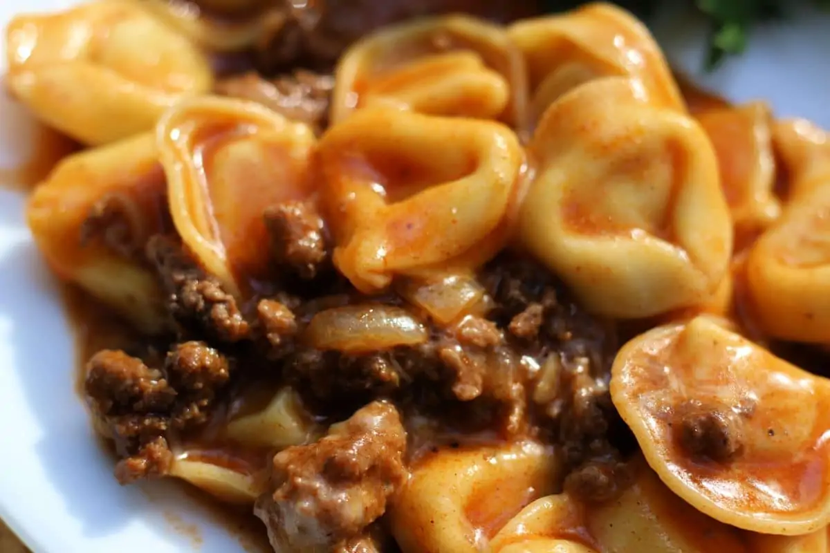 Cheesy Beef Enchilada Tortellini--an easy dinner made with ground beef, cheese tortellini, red enchilada sauce and melty cheese, make it in the slow cooker or Instant Pot.