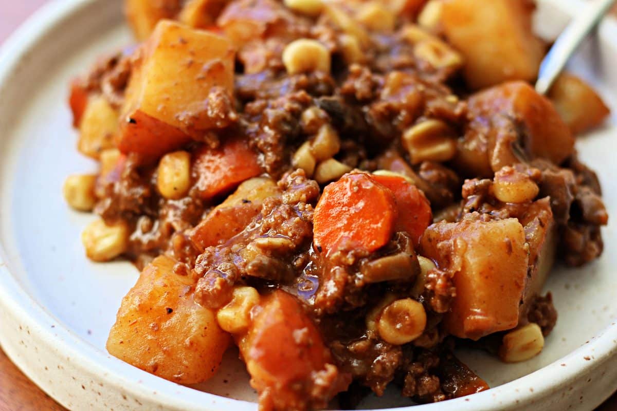 Farm House Beef Potato Gravy Casserole--an easy Crockpot meal made with ground beef, tender potatoes, carrots, mushrooms and corn, all cooked together in a rich, savory beef gravy.