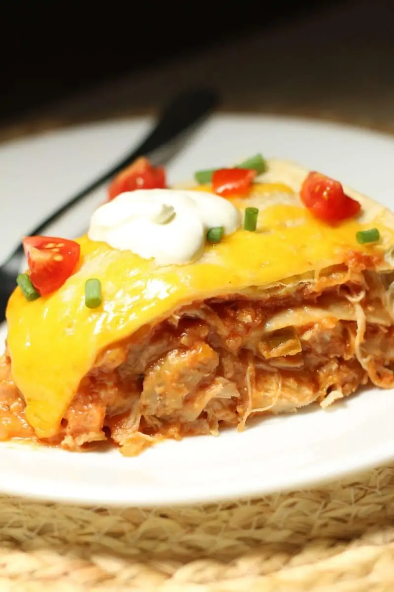 Mexican lasagna is made with layers of flour tortillas, shredded chicken, refried beans, salsa and melted cheddar cheese for a simple, cheesy dinner.